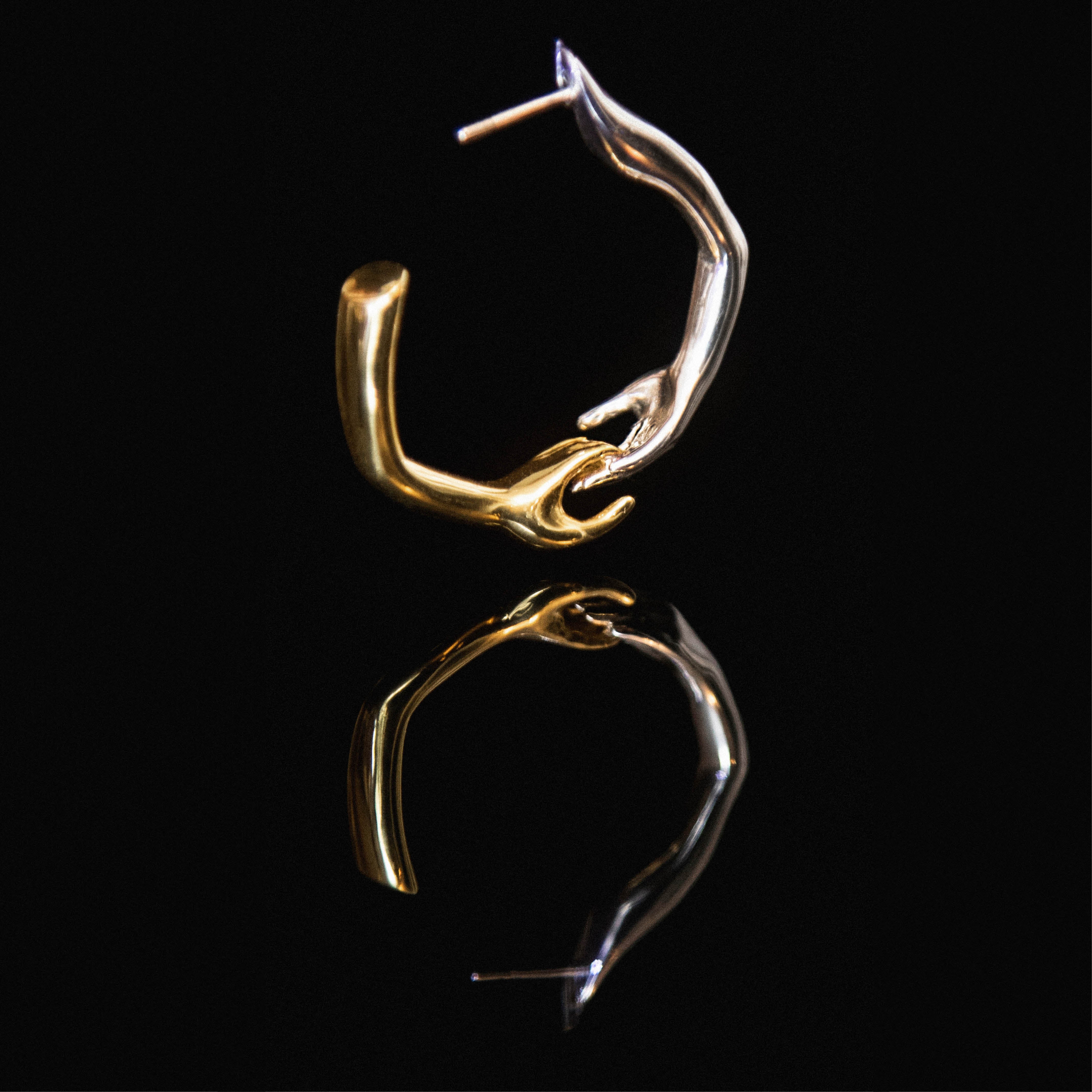 Paola Vilas Brinco Argola Lui escultura vestível em que duas mãos se unem disponível em prata 925 ou prata 925 com banho de Ouro 18k.