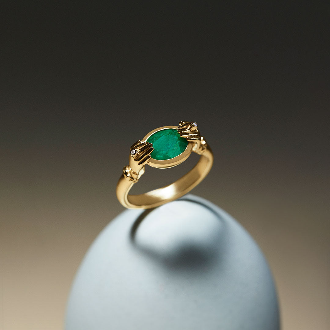 Anel em ouro 18k de mãos com diamantes e esmeralda oval