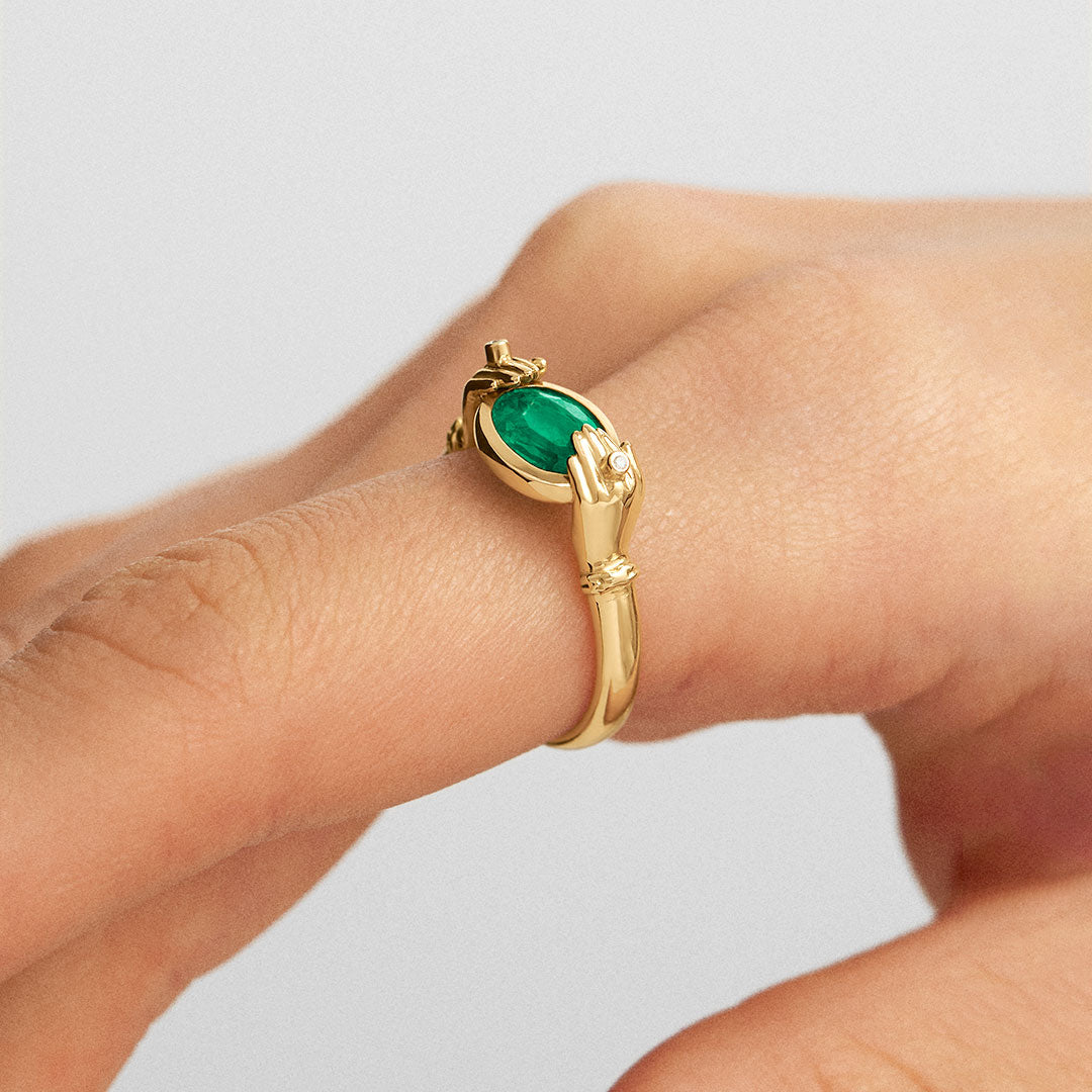Modelo usando anel de mãos em ouro 18k adornado com diamantes e esmeralda oval