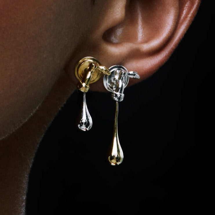 Paola Vilas O Brinco Mate Leoa faz uma releitura surrealista e feminina do Mate Leão, bebida simbólica das praias cariocas. As torneiras são recriadas trazendo padrões de curvas e abridores em formato de mãos. Gotas pingam se tornando seios. Joias Femininas 