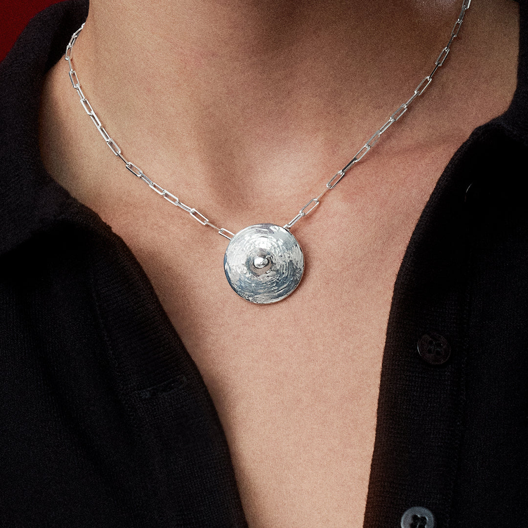 A Joia Paola Vilas Pendente Cecília é uma escultura vestível com formato de mamilos feita em prata 925, em formato de corpo.