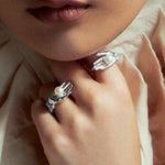 Modelo veste anéis em prata 925 de mãos com pérola botão