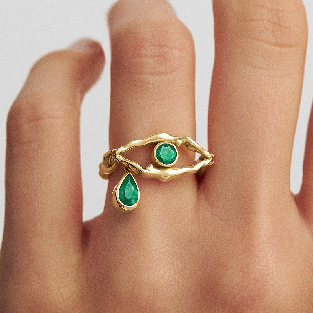 Modelo usando anel em ouro 18k de corpos em formato de olho adornado com esmeraldas