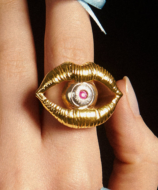 Modelo usando anel em prata 925 e banho de ouro 18k de boca e olho com rubi