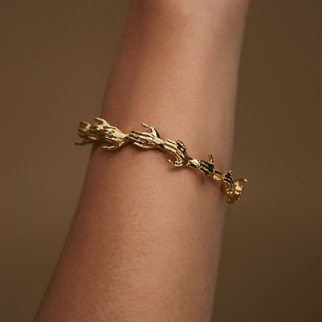 Modelo usando pulseira de mãos em corrente de prata 925 com banho de ouro 18k