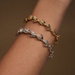 Modelo usando baceletes de mãos em corrente de prata 925 com banho de ouro 18k e esmeraldas