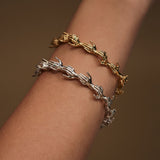 Modelo usando baceletes de mãos em corrente de prata 925 com banho de ouro 18k e esmeraldas