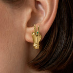 Modelo usando brinco de mão com sinal de paz em prata 925 com banho de ouro 18k e esmeralda