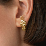 Modelo usando brinco de mão com sinal de paz em prata 925 com banho de ouro 18k