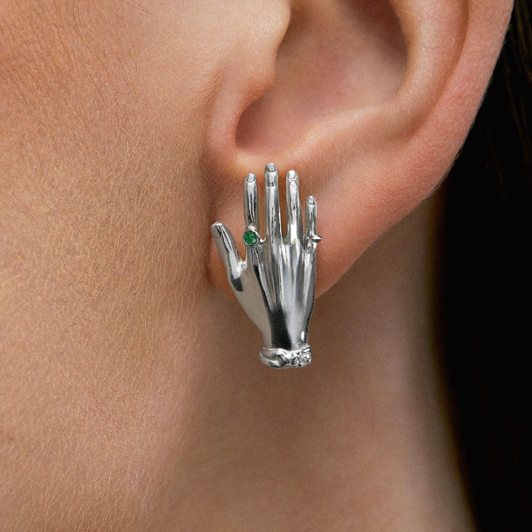 Modelo usando brinco de mão em prata 925 e esmeralda