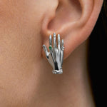 Modelo usando brinco de mão em prata 925 e esmeralda