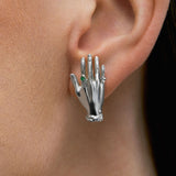 Modelo usando brinco de mão em prata 925 e esmeralda