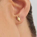 Modelo usando brinco em ouro 18k de mini dedo do meio adornado com diamante