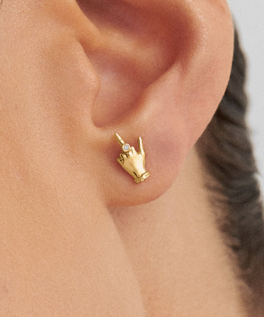 Modelo usando brinco em ouro 18k de mini dedo do meio adornado com diamante