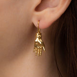 Modelo usando brinco de palma da mão e prata 925 com banho de ouro 18k