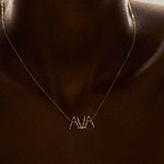 Modelo usando colar em ouro 18k personalizável de nome com letras em forma de corpos femininos