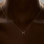 Modelo usando colar em ouro 18k de letra do alfabeto em forma de corpos femininos