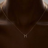 Modelo usando colar em ouro 18k de letra do alfabeto em forma de corpos femininos