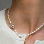 Modelo usando colar de pérolas com fecho de mão em prata 925 adornado com esmeralda