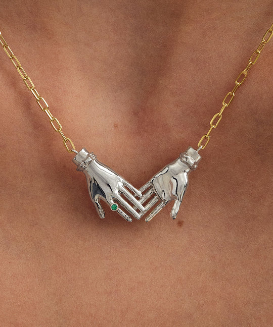 Modelo usando colar em prata 925 com corrente banhada em ouro 18k de mãos dadas adornado com esmeralda