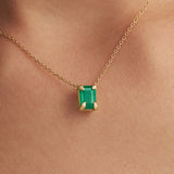 Modelo usando colar em ouro 18k de mãos e esmeralda retangular
