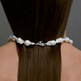 Modelo usando colar de pérolas barrocas com fecho de mão em prata 925 e esmeralda