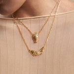 Modelo usando colares em prata 925 e banho de ouro 18k de mãos adornadas de esmeraldas