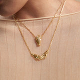 Modelo usando colares em prata 925 e banho de ouro 18k de mãos adornadas de esmeraldas