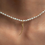 Modelo usando pendente em ouro 18k de cílio em colar de pérolas