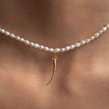 Modelo usando pendente em ouro 18k de cílio em colar de pérolas