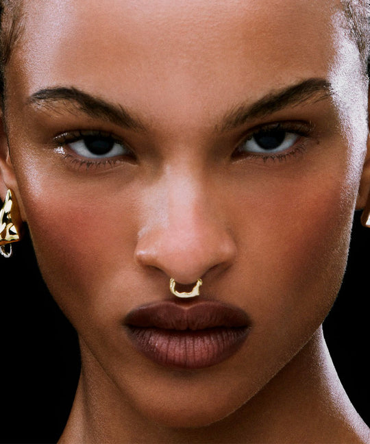 Modelo usando piercing de pressão em prata 925 com banho de ouro 18k de corpo feminino