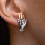 Modelo usando brinco de mão em prata 925 adornado com esmeralda