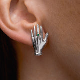 Modelo usando brinco de mão em prata 925 adornado com esmeralda